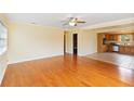 Bright living room featuring hardwood floors, white ceilings, and an open layout to the kitchen at 212 Gulf Ave, Nokomis, FL 34275