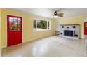 Bright living room featuring a large window, red door, ceiling fan, and a decorative brick fireplace at 217 Palm E Ave, Nokomis, FL 34275
