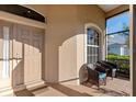 A charming screened-in entryway with tile flooring and comfortable seating for guests at 2363 Jasmine Way, North Port, FL 34287