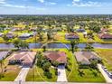 Aerial view showcasing a well-maintained home with lush landscaping, serene canal frontage, and surrounded by a vibrant neighborhood at 32 Long Meadow Ln, Rotonda West, FL 33947
