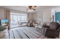 Bright living room with sliding glass doors to the porch, comfortable seating, and lots of natural light at 3249 Sunrise Trl, Port Charlotte, FL 33952