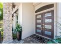 Stylish front entrance with stone accents, a modern door, and lush potted plants at 3657 Aruba Ct, Punta Gorda, FL 33950