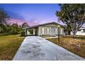 Charming single-story home with a covered carport and mature trees in a well-maintained front yard at 4477 Shady Ln, Punta Gorda, FL 33980