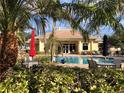Resort-style community pool and clubhouse surrounded by lush tropical landscaping and comfortable lounge seating at 6379 Grand Cypress Blvd, North Port, FL 34287