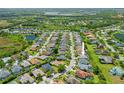 Wide aerial shot showcases the property's location in a tranquil neighborhood with ponds and mature trees at 7344 Arrowhead Run, Lakewood Ranch, FL 34202