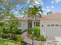 Beautiful home featuring manicured landscaping, a two-car garage, and a charming walkway to the front door at 7344 Arrowhead Run, Lakewood Ranch, FL 34202