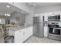 A modern kitchen featuring stainless steel appliances, white cabinets, and a granite countertop island at 1211 Saxony Cir # B5, Punta Gorda, FL 33983