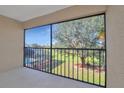 A screened porch features view of the lawn, trees, and neighborhood, for relaxing outdoors at 1211 Saxony Cir # B5, Punta Gorda, FL 33983