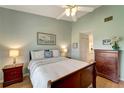 Comfortable bedroom with ceiling fan, light green walls, wood floors and dressers at 1235 Saxony Cir # 5202, Punta Gorda, FL 33983