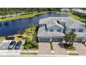Aerial view of townhomes with lake view featuring private garages, paver driveways and professional landscaping at 14617 Sycamore Ct # 2211, Punta Gorda, FL 33955