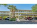 Exterior shot of condo building showing parking and entrance with attractive landscaping at 19325 Water Oak Dr # 305, Port Charlotte, FL 33948