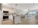 Open-concept kitchen/living room with stainless steel appliances and balcony access at 19325 Water Oak Dr # 305, Port Charlotte, FL 33948