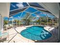 Screened-in pool and patio overlooking a serene waterfront view, perfect for relaxing outdoors at 2244 Meetze St, Port Charlotte, FL 33953