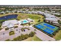 Aerial view of the community showcasing the pool, tennis courts, clubhouse, and serene landscaping at 25559 Heritage Lake Blvd # 25, Punta Gorda, FL 33983