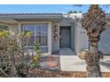 Inviting home entrance featuring a decorative palm tree, stepping stones, and stylish wall decor at 3106 Heron Shores Dr, Venice, FL 34293