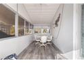 Enclosed patio with wall to wall windows, white table and chairs and decorative wall art at 5179 Grobe St, North Port, FL 34287