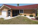 Close-up view of the home's exterior with a screened entryway, red roof, and well-kept landscaping at 612 Macedonia Dr, Punta Gorda, FL 33950