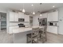 Bright kitchen featuring white cabinets, stainless steel appliances, and a granite countertop island with barstool seating at 8117 Thruso Rd, Port Charlotte, FL 33981
