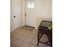 Welcoming entryway with tile floors, decorative front door, and wicker accent table at 1270 Manor Rd, Englewood, FL 34223