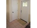 Bright entryway featuring tile flooring, a decorative front door, and fresh, neutral paint at 1270 Manor Rd, Englewood, FL 34223
