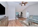 Spacious living room with hardwood floors, neutral paint and ceiling fan transitioning to dining area with vaulted ceilings at 13575 Clara Ln, Port Charlotte, FL 33981