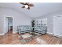 Comfortable living room featuring wood floors, ceiling fan, two gray couches, and an area rug, complemented by soft lighting at 13575 Clara Ln, Port Charlotte, FL 33981