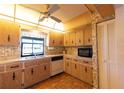 Cozy kitchen featuring wood cabinets, black appliances, and a double basin sink at 1497 Fireside St, Port Charlotte, FL 33952