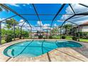Private screened-in pool and patio area, surrounded by lush landscaping and offering views of the canal and waterfront at 200 Capri Isles Ct, Punta Gorda, FL 33950