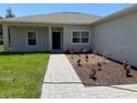 Inviting home exterior with a brick walkway leading to the front door and fresh landscaping at 20241 Lorette Ave, Port Charlotte, FL 33954