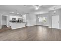 Open-concept living space featuring hardwood floors, modern lighting, and a view of the kitchen at 20241 Lorette Ave, Port Charlotte, FL 33954