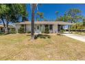 Inviting single-story home featuring mature landscaping and a covered carport at 2690 Auburn Blvd, Port Charlotte, FL 33948