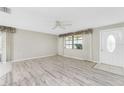 Bright living room showcasing wood-look floors, neutral walls, and a ceiling fan at 2690 Auburn Blvd, Port Charlotte, FL 33948