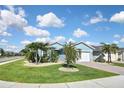 Charming single-Gathering home featuring a lush green lawn and meticulously landscaped front yard with palm trees at 28059 Arrowhead Cir, Punta Gorda, FL 33982