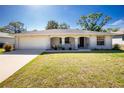 Charming single-story home with attached garage and a cozy front porch with decorative columns and green lawn at 2903 Pope St, North Port, FL 34287