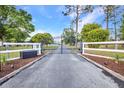 Gated entrance with white fencing and well-maintained landscaping, adding curb appeal and security to the property at 29324 Leah Rd, Punta Gorda, FL 33982