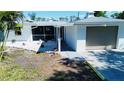 Exterior view of the house featuring a screened in porch, one car garage, and rock landscaping at 352 Oak St, Englewood, FL 34223