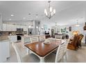 Open-concept kitchen featuring white cabinets, stainless steel appliances, and an island at 3621 Jade St, North Port, FL 34288