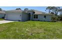 Lovely one-story home with an attached garage, manicured lawn, and a welcoming facade at 369 Biltmore St, Port Charlotte, FL 33953
