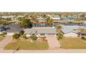 Charming single-story home boasts a well-manicured lawn, mature palms, and a brick driveway near the waterfront at 441 Norma Ct, Punta Gorda, FL 33950