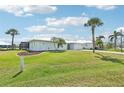 Desirable single-story home with a lush front lawn, mature palm trees, and a metal roof at 5194 Cooper Ter, Port Charlotte, FL 33981