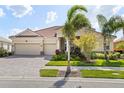 Attractive one-story home with three-car garage, red tile roof, paved brick driveway, and well-maintained landscaping at 5428 Royal Poinciana Way, North Port, FL 34291