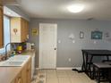Functional kitchen featuring wood cabinets, tile flooring, and a cozy dining area at 705 Crestview Nw Cir, Port Charlotte, FL 33948