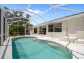 Screened in pool area features a private in-ground pool with a spacious deck and an outdoor dining area at 13235 Essman Ave, Port Charlotte, FL 33953