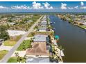 Scenic aerial view of canal-front homes with lush landscaping, boat docks, and ocean views in a beautiful neighborhood at 15762 Aqua Cir, Port Charlotte, FL 33981