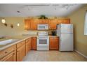 Open concept kitchen featuring white appliances and light wood cabinets and tile flooring at 175 Kings Hwy # 226, Punta Gorda, FL 33983