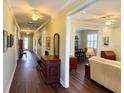Long hallway featuring hardwood floors connecting multiple rooms and a rear entryway door at 2227 Bonn Ct, Punta Gorda, FL 33983