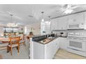 Bright kitchen with white cabinets, granite countertops, and an open view to the dining and living areas at 25100 Sandhill Blvd # R202, Punta Gorda, FL 33983
