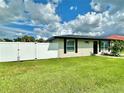 Charming home with a well-manicured lawn and a classic white fence, offering curb appeal and security at 3324 Port Charlotte Blvd, Port Charlotte, FL 33952