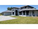 Elegant two-story home with a stately entrance, manicured lawn, and a gray brick driveway at 384 Viedma St, Punta Gorda, FL 33983