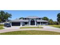 Beautiful two-story home with a paved driveway, manicured lawn, gray siding, and an attached two-car garage at 384 Viedma St, Punta Gorda, FL 33983